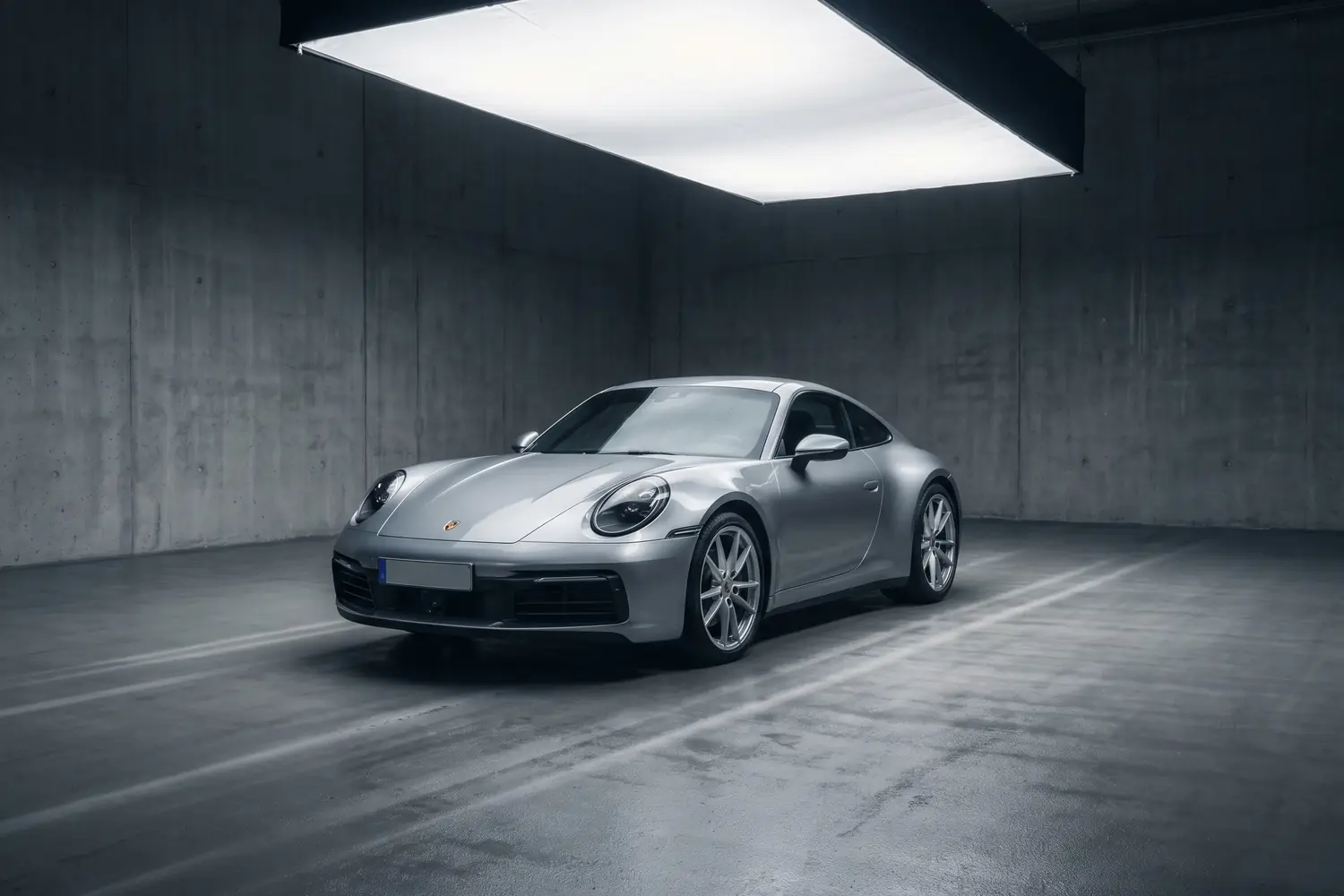 Porsche 911 Carrera argent dans un studio en béton.