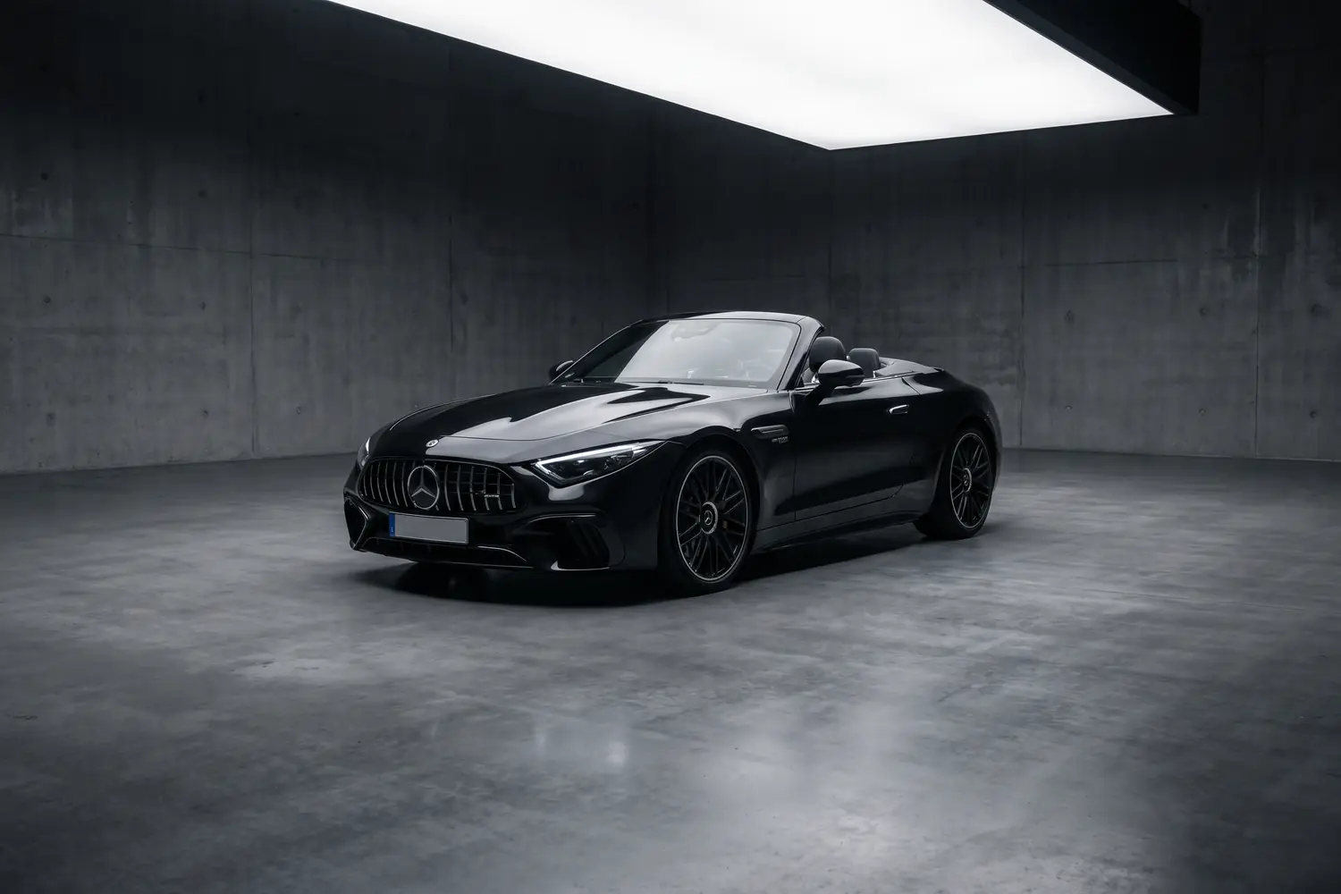 Mercedes-AMG SL noir décapotée dans un studio en béton.