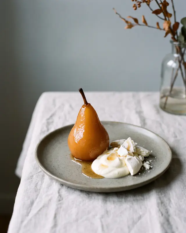 Poire Williams pochée entière, crème double et éclats de meringue.